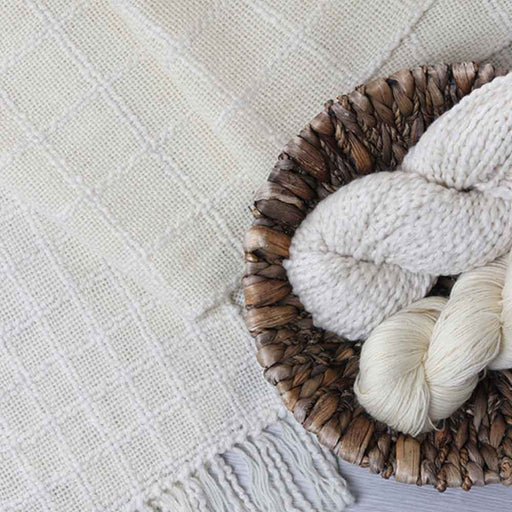 Close-up of the Ashford Weaving Kit 1 – Lattice Scarf showing handwoven lattice texture and natural undyed yarns in a woven basket.