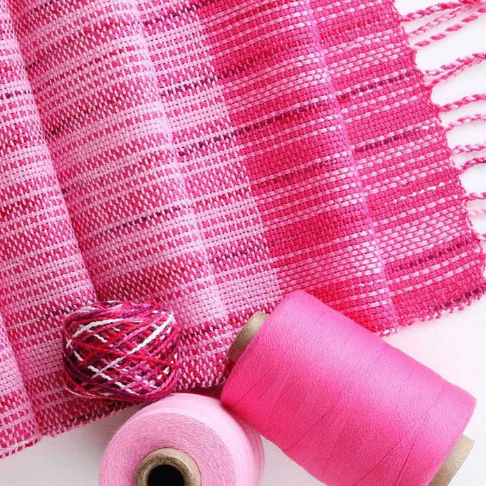 Close-up of the bright pink cotton scarf woven with the Ashford Weaving Kit 2 – Spring colorway, featuring Ashford unmercerised cotton and Caterpillar Cotton yarns.