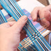 Student weaving an inkle band during a weaving class