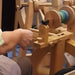 Spinner learning to spin a two-ply yarn on a spinning wheel during a workshop at Tisse et File