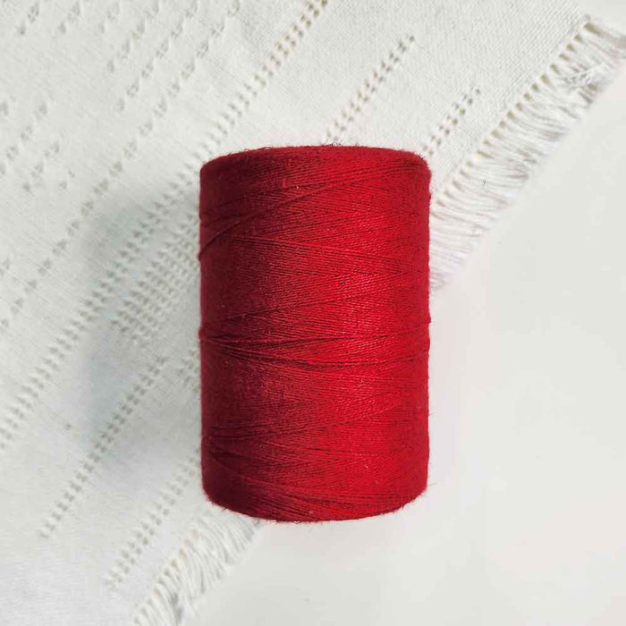 Cone of cerise cotolin weaving yarn by Brassard