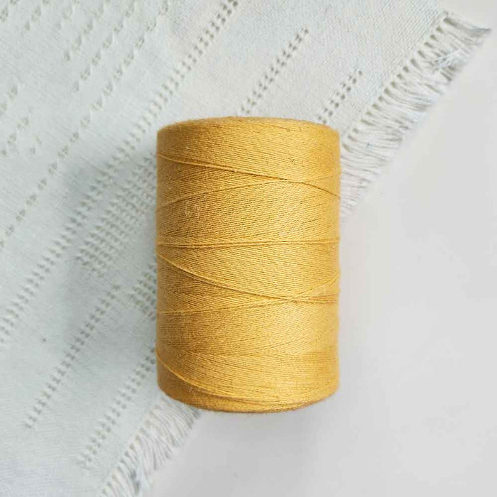 Cone of jaune or cotolin weaving yarn by Brassard