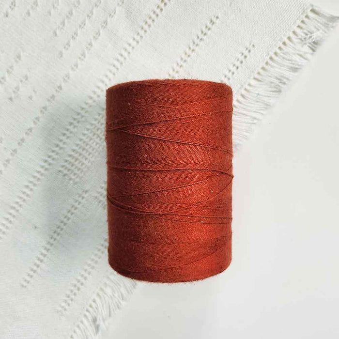 Cone of rouille cotolin weaving yarn by Brassard