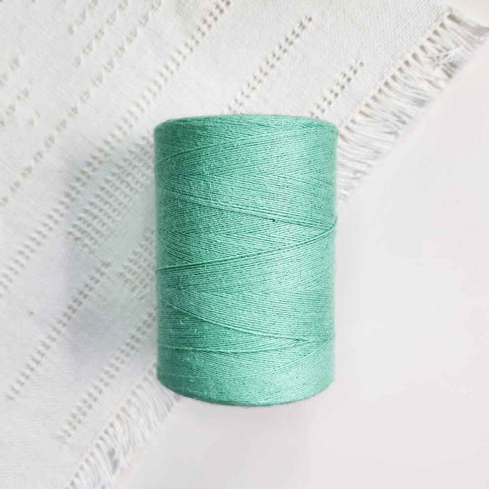 Cone of turquoise cotolin weaving yarn by Brassard