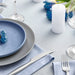 French-inspired table setting featuring blue linen and elegant tableware