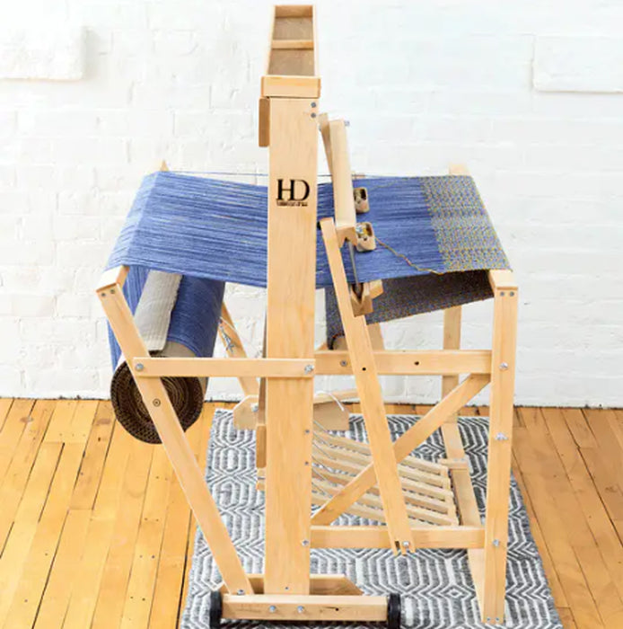 Side view of Harrisville Designs 4-shaft floor loom weaving blue cloth