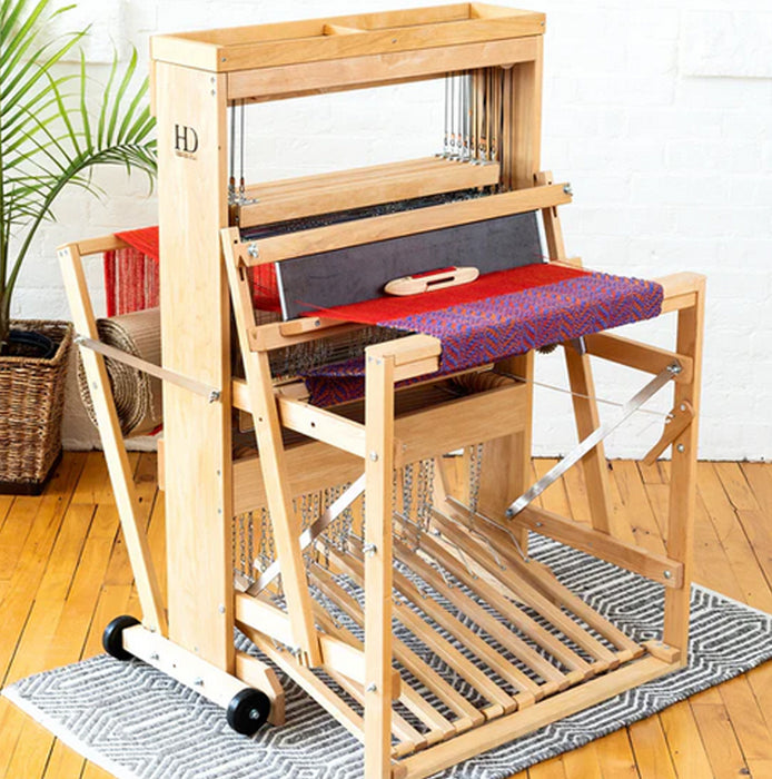 Harrisville Designs 8-shaft floor loom front view with red fabric in progress