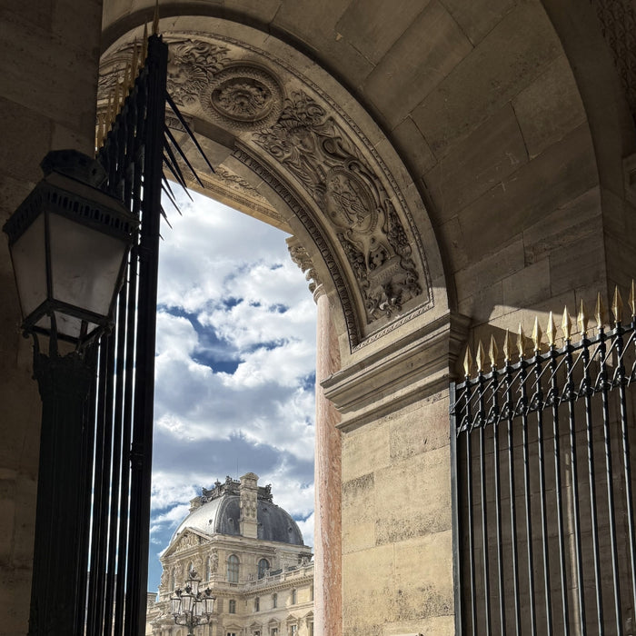 Historic Parisian archway symbolizing the beginning of a textile journey through France