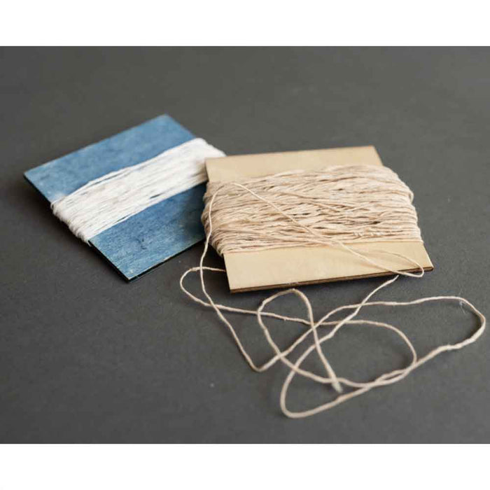 Paper samples and prepared Japanese paper yarn used for fiber art projects
