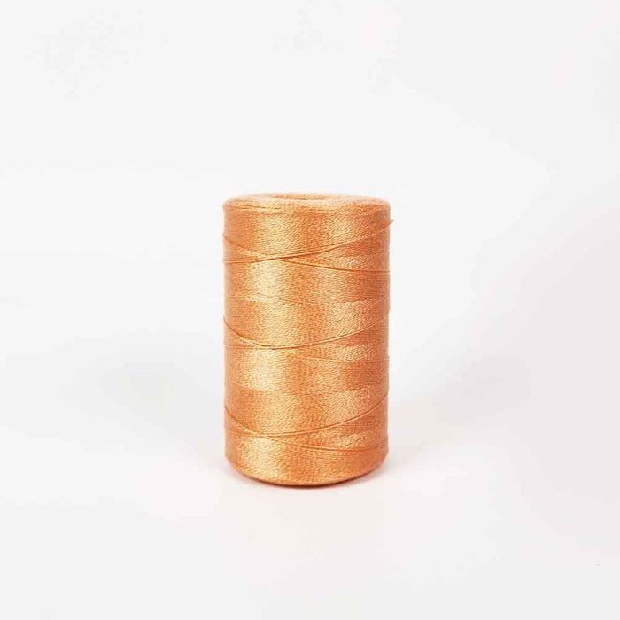 Orange pâle Tencel yarn spool by Maurice Brassard for weaving projects