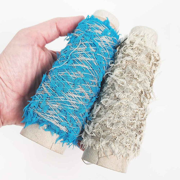 Mondofil Papiyon novelty yarn cones in blue and natural held in hand