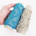 Mondofil Papiyon novelty yarn cones in blue and natural held in hand