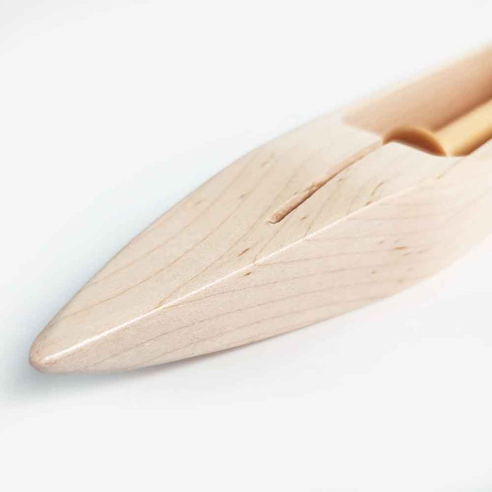 Close-up of the pointed end of a Leclerc maple weaving shuttle with smooth finish