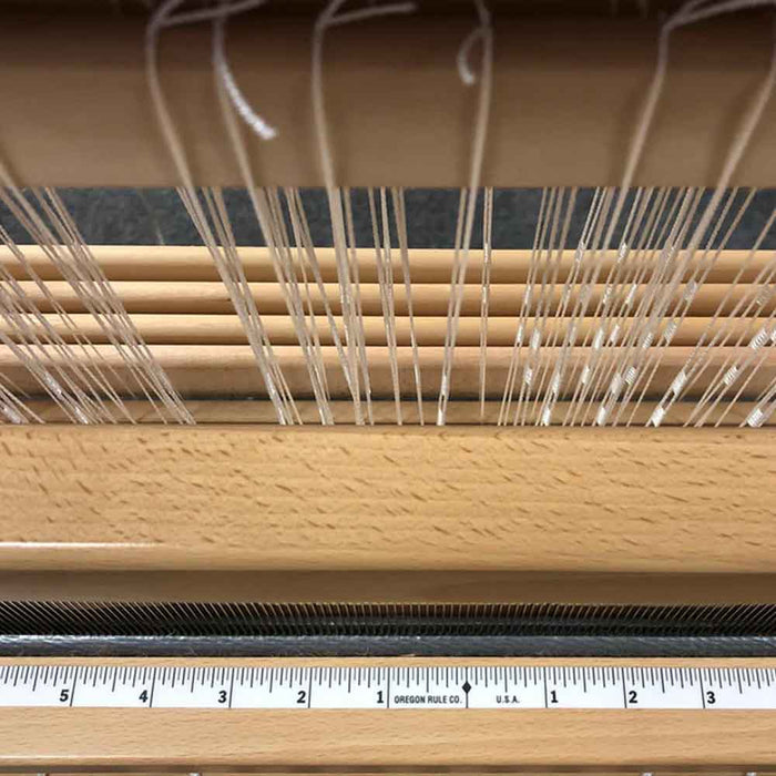 Self-adhesive centering tape installed on a loom beater for accurate warp alignment.