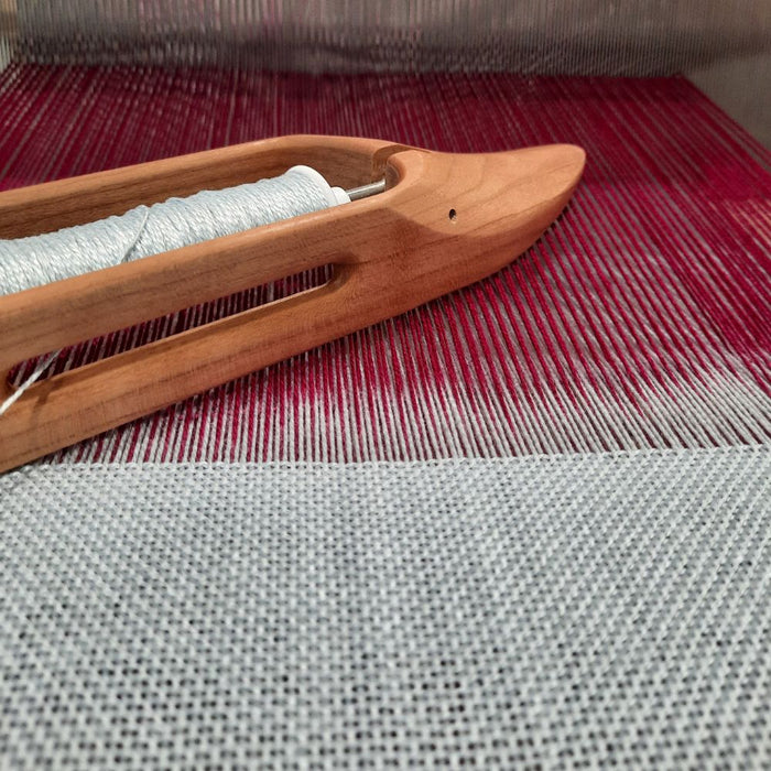 Layered double weave in progress with shuttle on a four-shaft loom