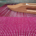 Double weave sample in progress with wooden shuttle on a four-shaft loom