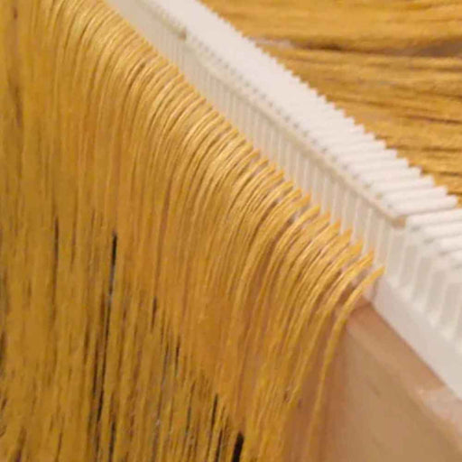 Warp threads distributed through a Lofty Fiber raddle on a Harrisville Designs loom