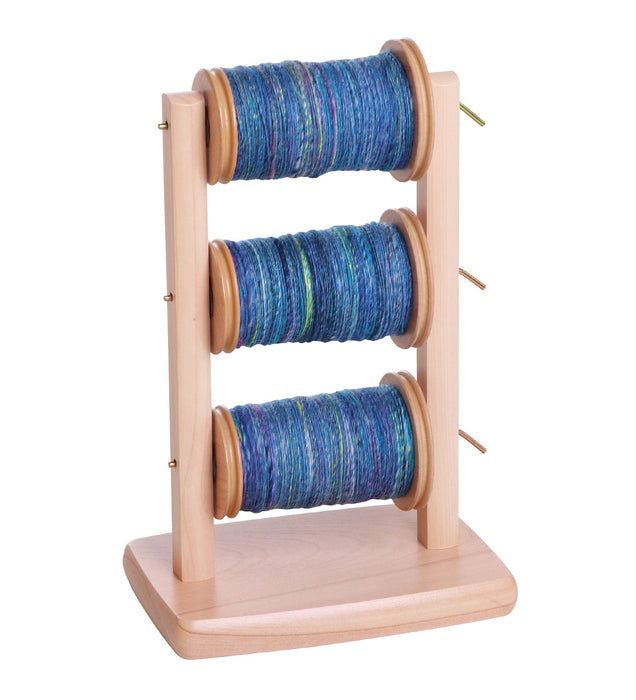 Ashford spinning wheel lazy kate with multiple bobbins filled with yarn